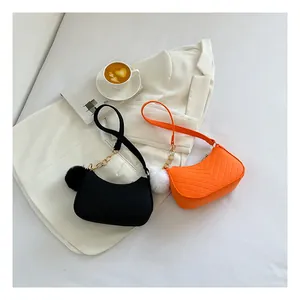 Detail van gewatteerde schoudertassen met gouden ketting en zachte pompon hanger