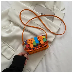 Close-up of a colorful mini crossbody bag with orange chain detail and mosaic leather pattern