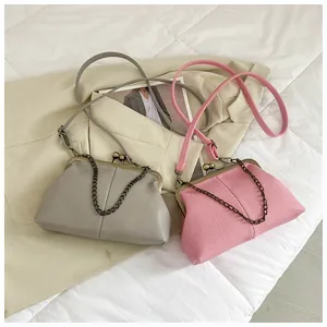 Detailed close-up of shell-shaped crossbody bags with litchi texture and metal clasp
