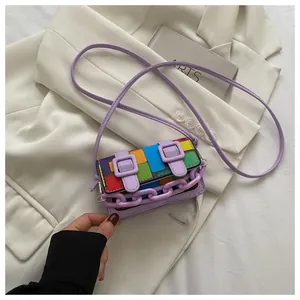 Close-up of a colorful checkered mini bag with purple chain and double buckle straps