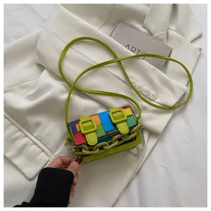 Macro shot of colorful geometric mosaic bag with lime green chain and decorative belt