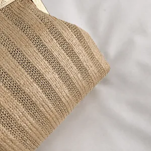 Détail du tissage en paille et du cadre en métal doré orné sur un sac pochette coquille