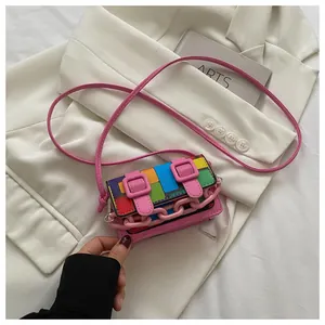 Macro detail of a mini color-block crossbody bag featuring bold buckles and a pink chain