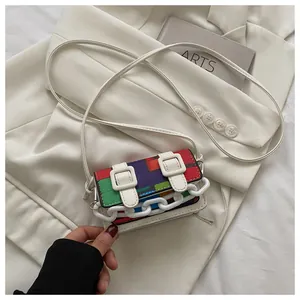 Close-up of multicolor geometric patchwork mini bag with white plastic chain and buckles