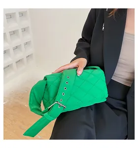 Détail d'un sac bandoulière vert vif matelassé avec une boucle à œillets métalliques