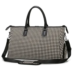 Borsa da viaggio capiente con classico motivo pied de poule bianco e nero e tracolla nera