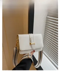 Vue détaillée du sac bandoulière blanc avec sangle chevron et boucle dorée