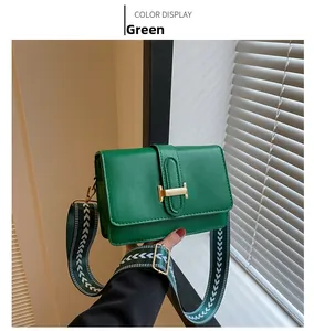 Détail du sac carré en similicuir vert avec boucle H dorée et bandoulière large à motifs