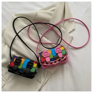 Detail of mini crossbody bag with colorful patchwork, plastic chain and buckle straps