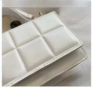 Gros plan sur la texture du cuir PU blanc matelassé avec coutures carrées détaillées