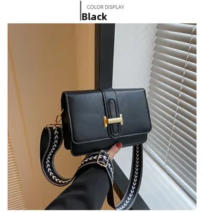 Sac bandoulière noir avec boucle H dorée et bandoulière tissée à motifs géométriques
