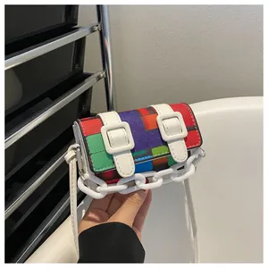 Close-up of a mini multicolored patchwork crossbody bag with decorative white plastic chain