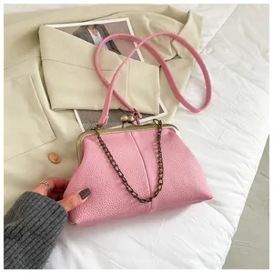 Detail of pink lychee grain shell bag featuring vintage metal clasp and chain strap