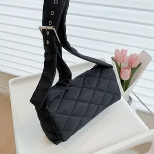 Sac à bandoulière matelassé noir avec large sangle à œillets et boucles en métal
