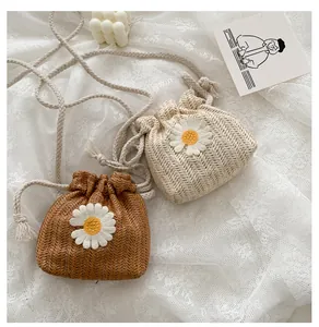 Close-up of mini woven straw bucket bags with daisy appliques in cream and tan colors