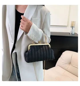 Détail d'un sac docteur noir texturé avec boucle dorée et bandoulière sur modèle