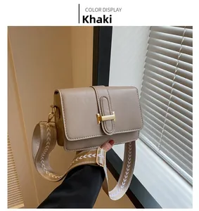 Détail d'un sac bandoulière kaki avec fermoir en H doré et sangle large à chevrons