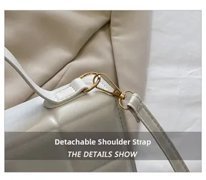 Détail de la bandoulière amovible avec crochet en métal doré sur le sac blanc