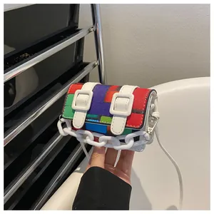 Detail of mini flap bag with colorful geometric mosaic patterns and white plastic chain