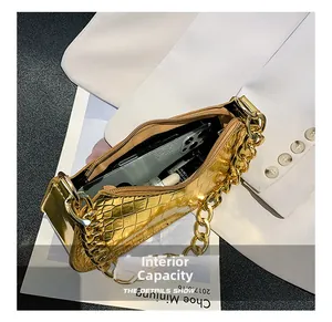 Detail shot of the internal capacity of a shiny gold crocodile texture handbag
