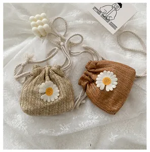 Close-up of straw bucket bags with daisy patches and cotton rope straps on lace