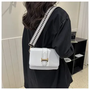 Détail d'un sac à bandoulière blanc en cuir PU avec large sangle géométrique