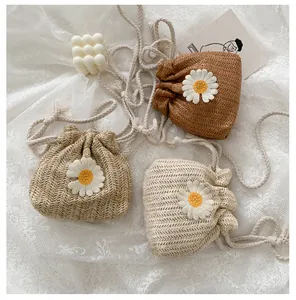 Detail showing handwoven straw bucket bags with daisy patches in three natural colors