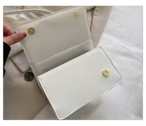 Détail de la sacoche matelassée blanche avec fermetures à double bouton aimanté doré
