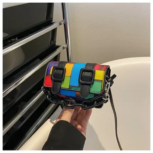 Detail of a mini multicolor patchwork bag with black chain and leather strap decor