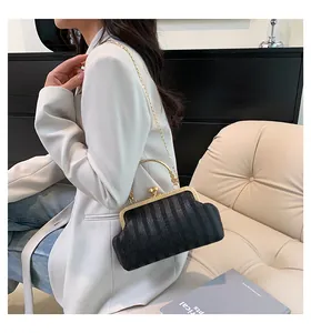 Détail du sac de soirée tissé noir avec poignée en métal doré et fermoir vintage chic