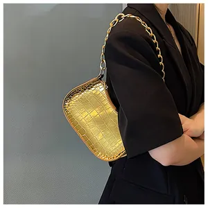 Detail of gold crocodile embossed underarm bag with sleek metallic chain strap