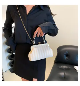 Détail du sac rétro à rayures beige avec poignée en perles et chaîne dorée