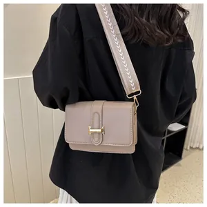 Détail d'un petit sac carré marron clair avec large bandoulière à motifs flèches