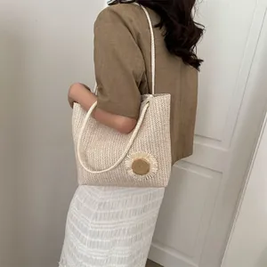 Close-up of beige straw tote bag with sunflower decor and woven rope handles