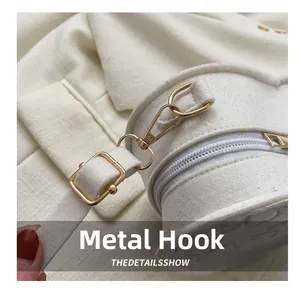Detailed close-up of premium gold-tone hardware hooks and buckles on white felt bag