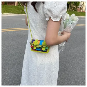 Detail view of mini crossbody bag with green chain and colorful geometric pattern