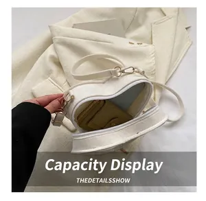 Detail view of white heart-shaped tweed crossbody bag showing interior storage space