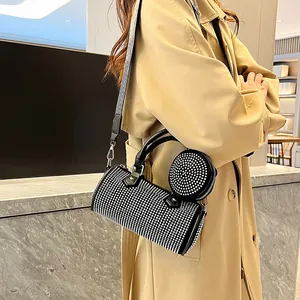 Detail of black rhinestone cylinder bag with wide wavy strap and mini round purse