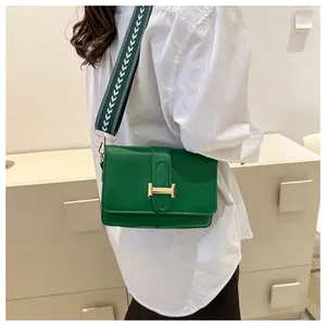 Détail d'un sac bandoulière en cuir vert avec boucle dorée et sangle à motifs