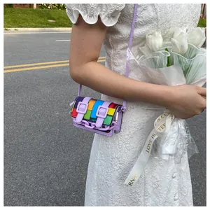 Detailed shot of a mini rainbow crossbody bag with purple chain strap and measuring scale
