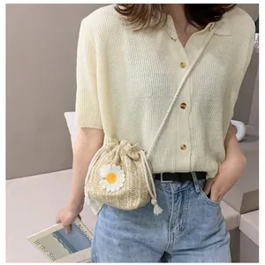 Chic beige straw bucket bag with white daisy embroidery and drawstring closure for summer
