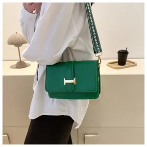 Sac bandoulière vert avec boucle H dorée et large bandoulière en tissu à motifs