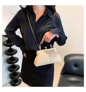 Gros plan d'un sac paille beige avec poignée perle et bandoulière chaîne dorée