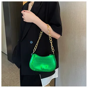 Close-up of vibrant green metallic crocodile pattern leather with gold chunky chain strap