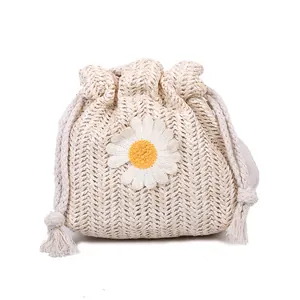 Chic woven straw bucket bag with white daisy flower and drawstring closure in beige