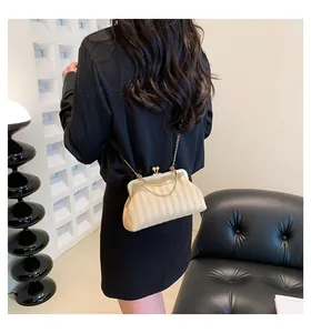 Détail du sac coquillage en paille beige avec cadre doré et fermoir à boule rétro