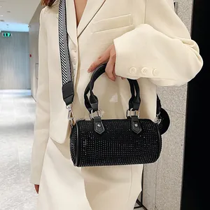 Detail of black rhinestone barrel bag with striped wide strap and leather handles