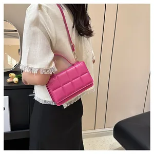Détail d'un sac bandoulière matelassé fuchsia porté par un mannequin féminin