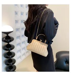 Détail du sac beige texturé avec bandoulière chaîne dorée et fermoir métallique vintage