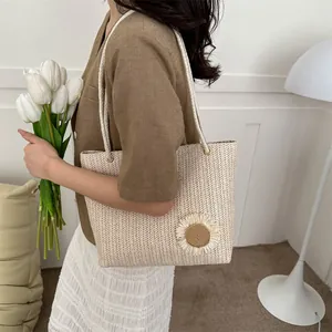 Detailed close-up of woven tote bag with 3D floral accent and thick rope handles